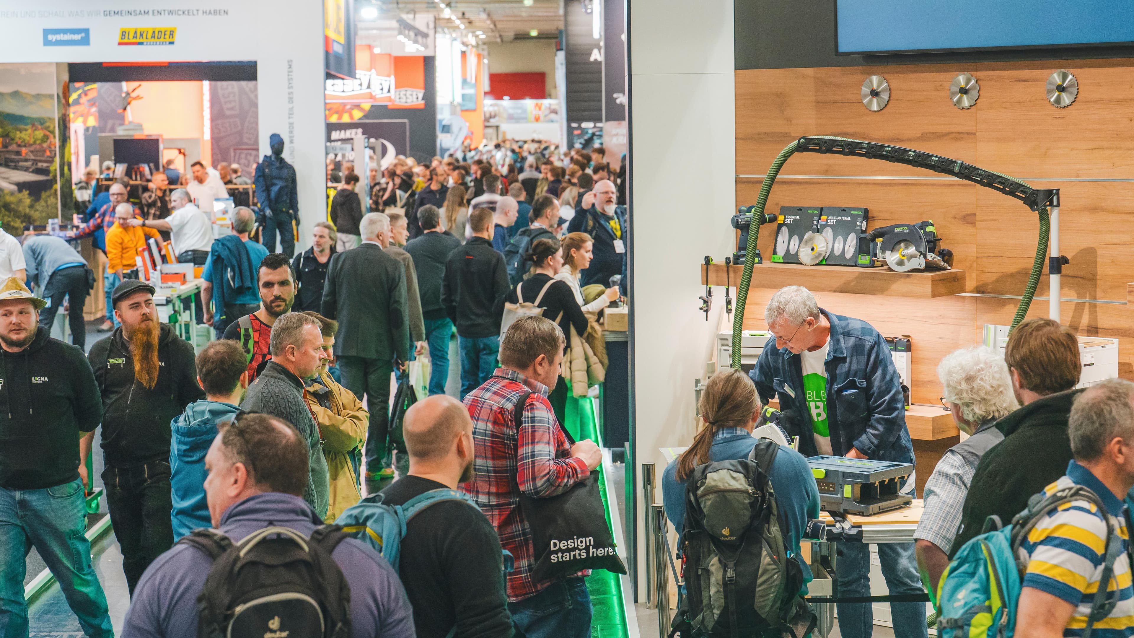 Crowded trade fair hall with many people and exhibition booths